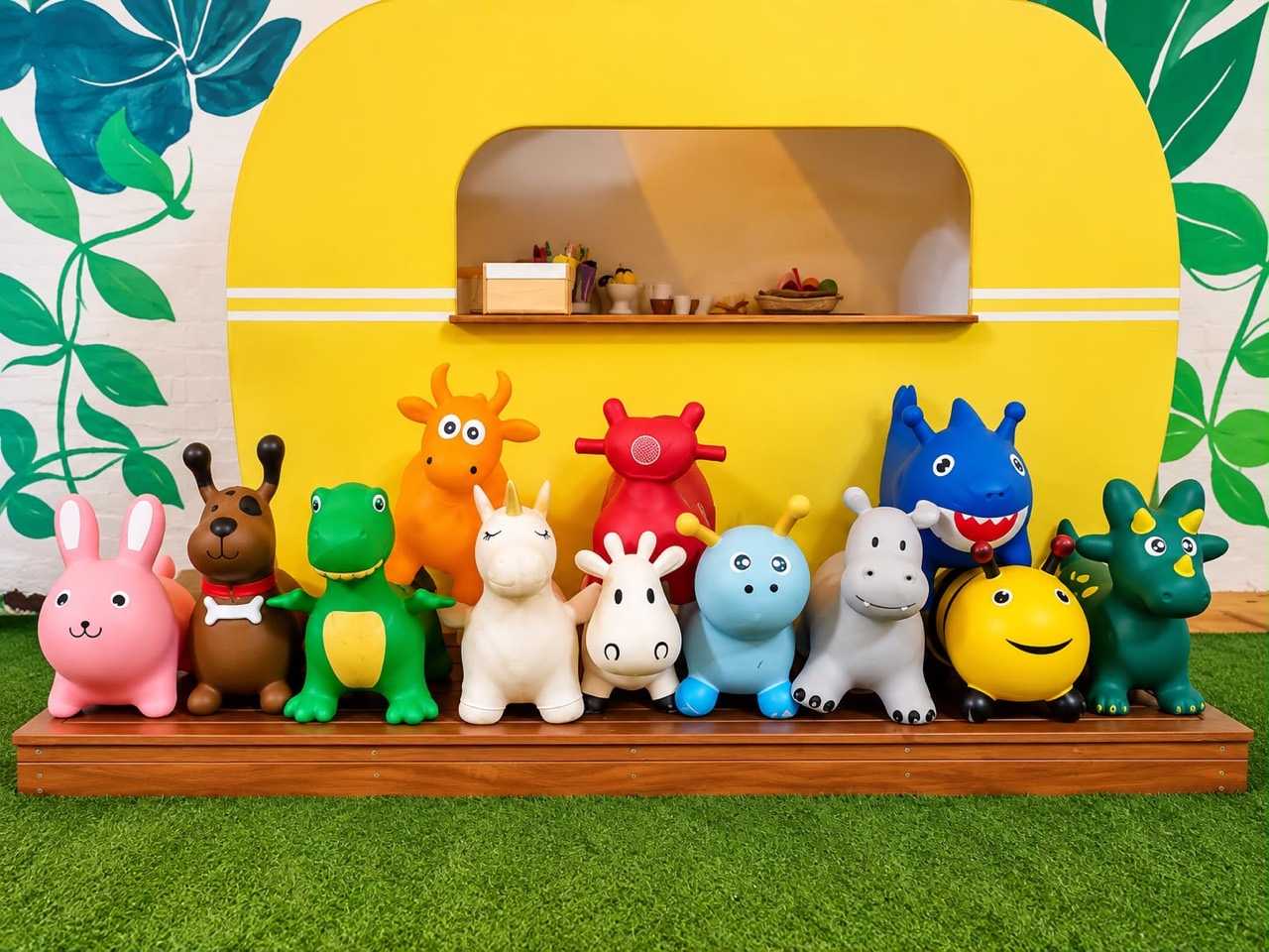 Colourful animal hoppers lined up in front of the yellow caravan cubby